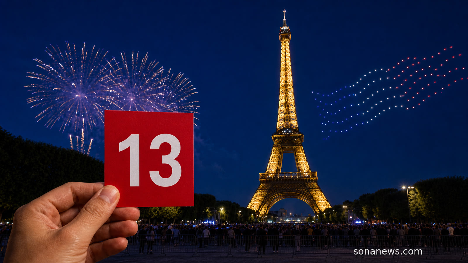 Main tenant une carte rouge marquée 13 devant la tour Eiffel illuminée, des drones et un feu d’artifice observés depuis le Champ-de-Mars.