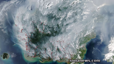 Citra satelit NASA memperlihatkan Kalimantan tertutup asap dengan banyak titik merah deteksi termal terutama di bagian selatan.
