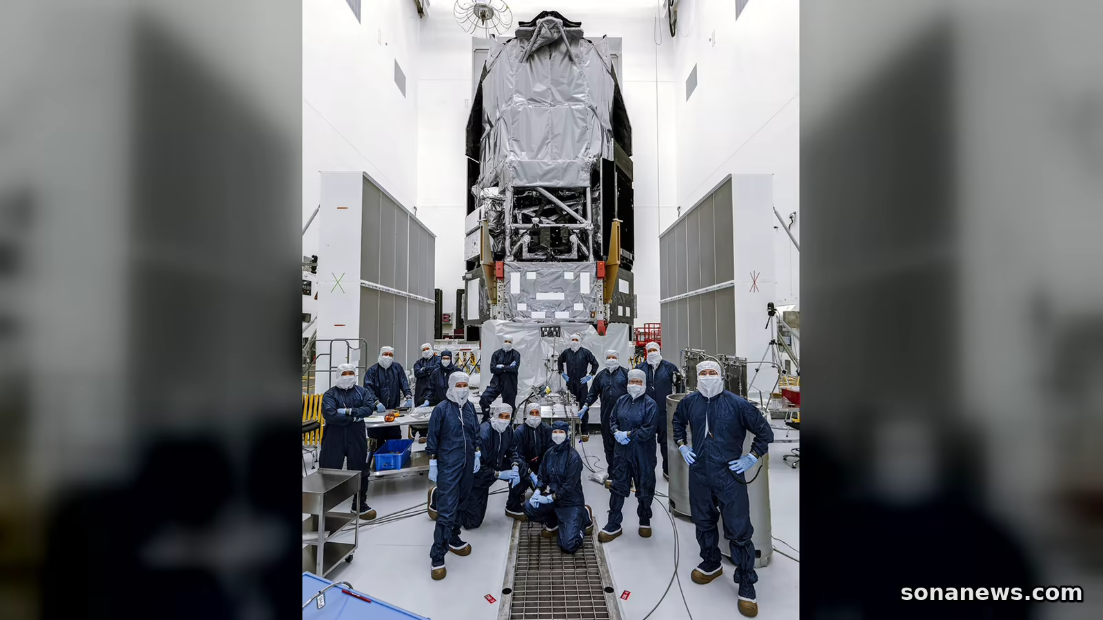 Observatorium Roman berdiri di ruang bersih Kennedy Space Center dengan tim berseragam pelindung biru berfoto di depannya sebelum peluncuran