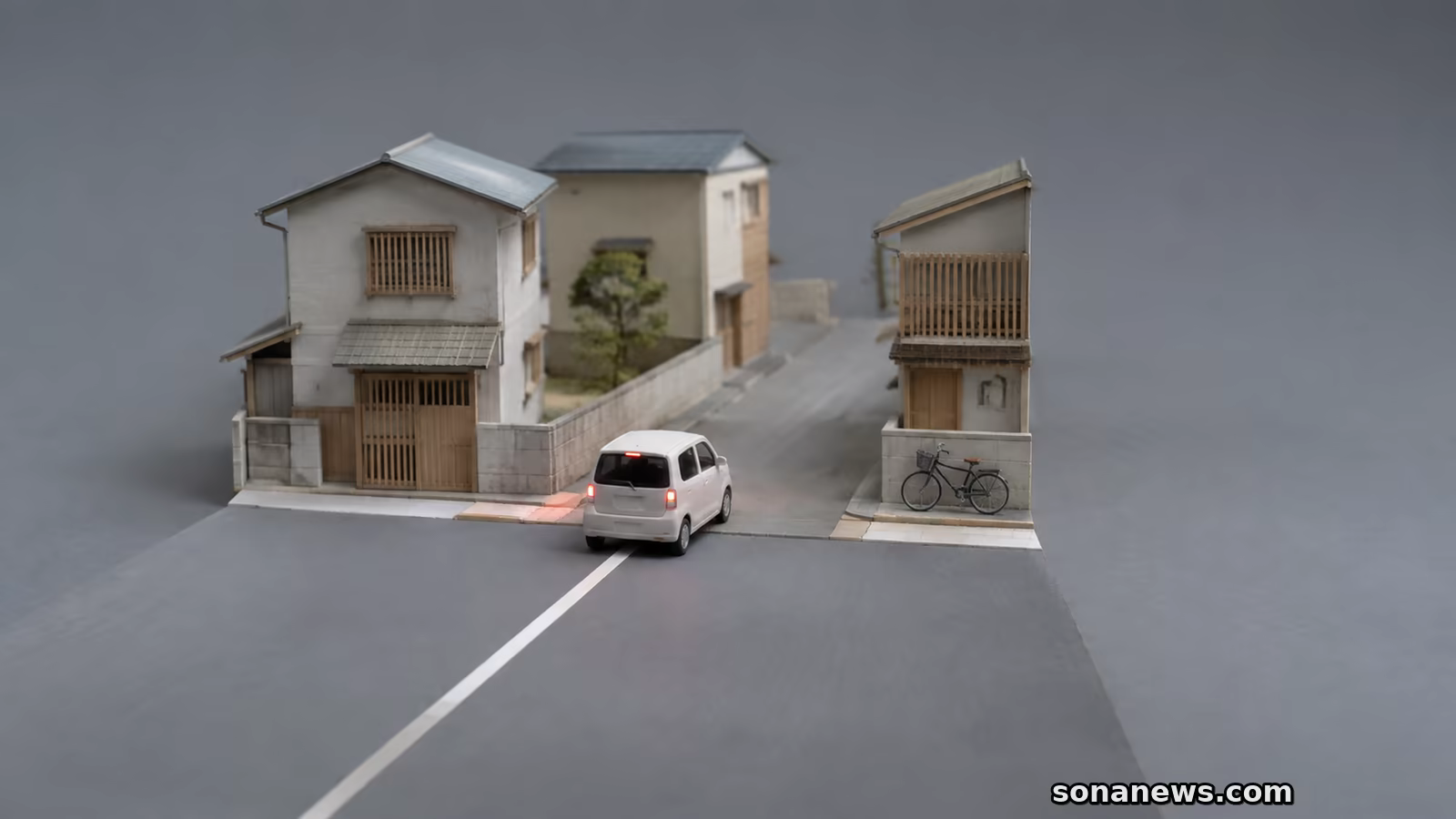 中央線のある道から線のない住宅街へ減速して入る白い車の概念模型